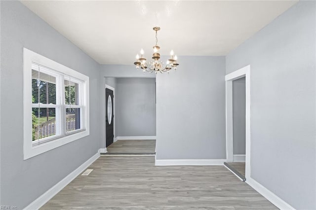 1250 27th St, Newport News, VA 23607 - unfurnished dining area with a chandelier, wood finished floors, and baseboards
