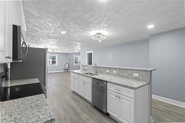 1250 27th St, Newport News, VA 23607 - kitchen featuring stainless steel dishwasher, a sink, baseboards, white cabinets, and a textured ceiling