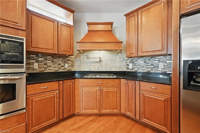 9628 7th Bay St Unit A, Norfolk, VA 23518 - kitchen featuring appliances with stainless steel finishes, custom range hood, light wood finished floors, and brown cabinets