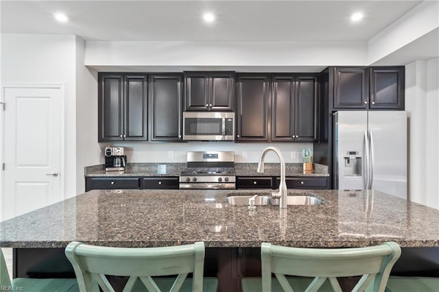 705 Mapleleaf Ln, Virginia Beach, VA 23462 - kitchen with stainless steel appliances, a sink, a kitchen bar, dark stone countertops, and a kitchen island with sink
