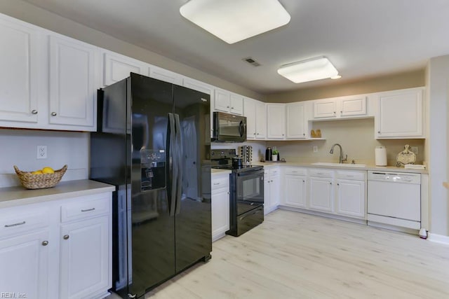 3914 Van Ness Dr, Virginia Beach, VA 23462 - kitchen with black appliances, a sink, and white cabinets