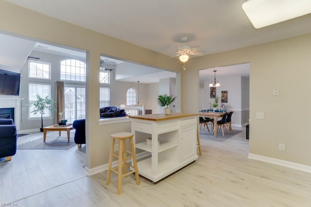 3914 Van Ness Dr, Virginia Beach, VA 23462 - kitchen with open floor plan, wood counters, light wood-style floors, white cabinetry, and a fireplace