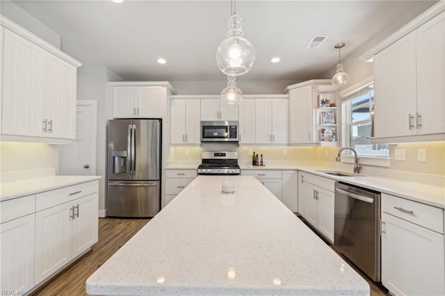 1328 Andreas Ln, Chesapeake, VA 23322 - kitchen with appliances with stainless steel finishes, a sink, a kitchen island, white cabinets, and wood finished floors