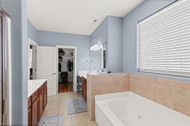 6309 Orchard Cove Ct, Suffolk, VA 23435 - bathroom featuring vanity, a whirlpool tub, a walk in closet, and tile patterned floors