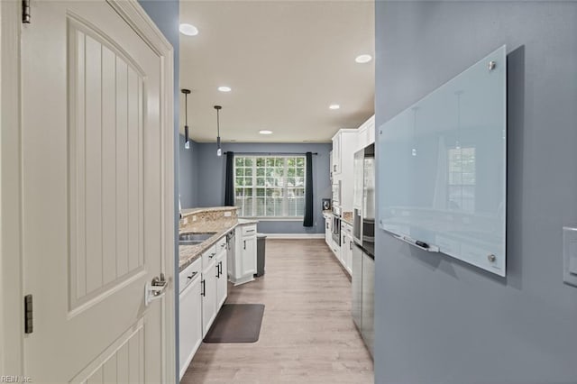 6309 Orchard Cove Ct, Suffolk, VA 23435 - kitchen featuring light wood-style floors, white cabinets, recessed lighting, light stone counters, and a sink