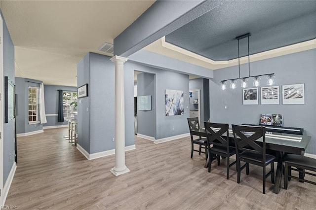 6309 Orchard Cove Ct, Suffolk, VA 23435 - dining area with ornate columns, baseboards, light wood-style floors, and a raised ceiling