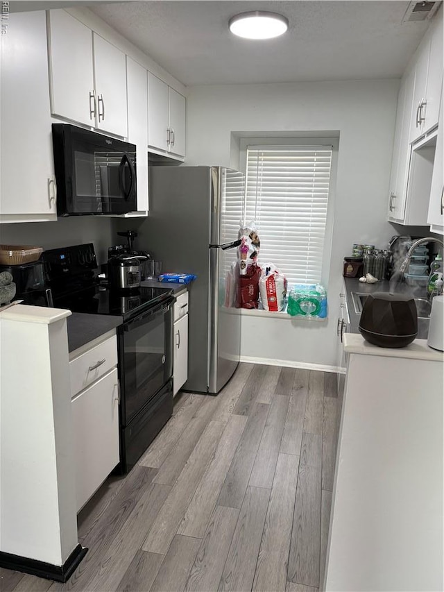3684 Windmill Dr, Virginia Beach, VA 23453 - kitchen featuring black appliances, light wood-style flooring, white cabinets, and baseboards