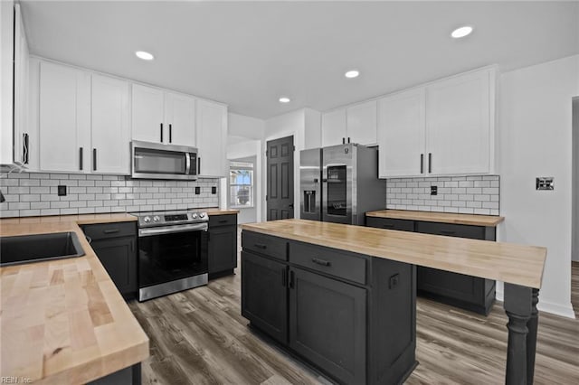 130 Rochdale Ln, Suffolk, VA 23434 - kitchen with butcher block countertops, appliances with stainless steel finishes, a sink, white cabinets, and dark wood finished floors