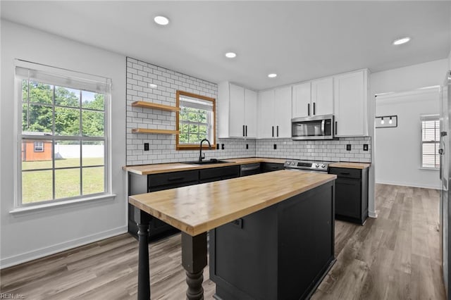 130 Rochdale Ln, Suffolk, VA 23434 - kitchen with wood counters, appliances with stainless steel finishes, a sink, white cabinets, and baseboards