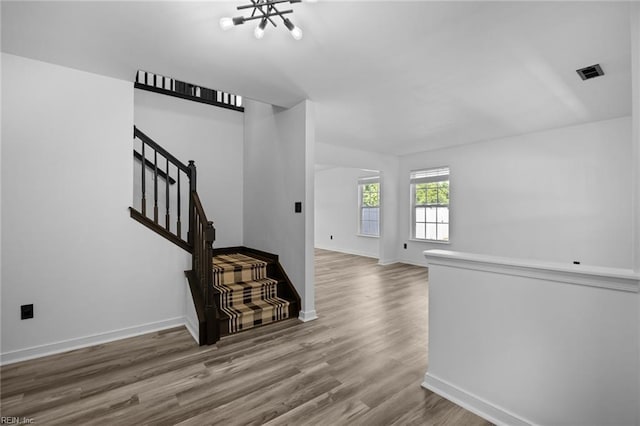 130 Rochdale Ln, Suffolk, VA 23434 - unfurnished living room with a chandelier, wood finished floors, baseboards, and stairs