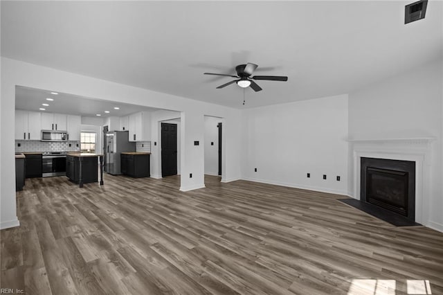 130 Rochdale Ln, Suffolk, VA 23434 - unfurnished living room featuring ceiling fan, dark wood finished floors, baseboards, a fireplace with flush hearth, and recessed lighting