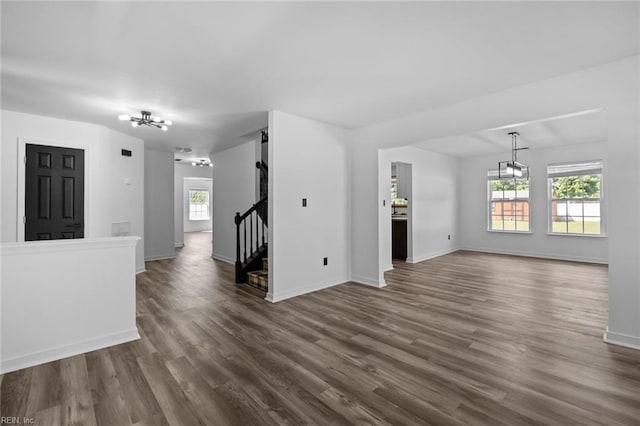 130 Rochdale Ln, Suffolk, VA 23434 - unfurnished living room featuring a chandelier, dark wood-style floors, baseboards, and stairway