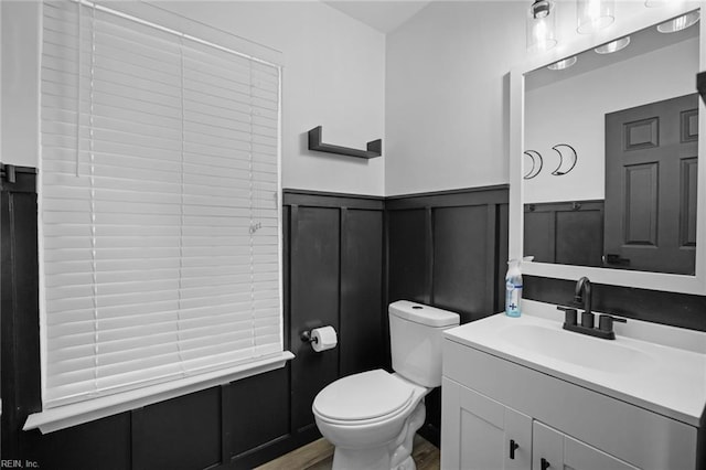 130 Rochdale Ln, Suffolk, VA 23434 - bathroom featuring wainscoting, toilet, a decorative wall, vanity, and wood finished floors