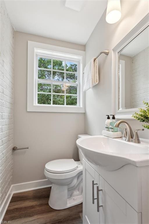 134 Chesterfield Rd, Hampton, VA 23661 - half bath with wood finished floors, vanity, baseboards, toilet, and brick wall