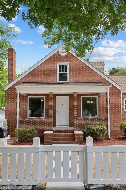 134 Chesterfield Rd, Hampton, VA 23661 - view of front facade with brick siding, a fenced front yard, and a chimney