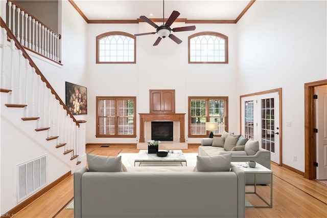 909 Two Gates Cir, Chesapeake, VA 23322 - living room featuring a ceiling fan, ornamental molding, healthy amount of natural light, a glass covered fireplace, and light wood finished floors