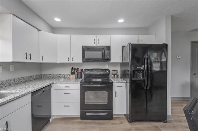 1628 Bourbon Ave, Norfolk, VA 23509 - kitchen with black appliances, light wood-style floors, white cabinets, recessed lighting, and light stone countertops