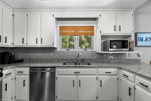 kitchen with appliances with stainless steel finishes, a sink, white cabinetry, and decorative backsplash