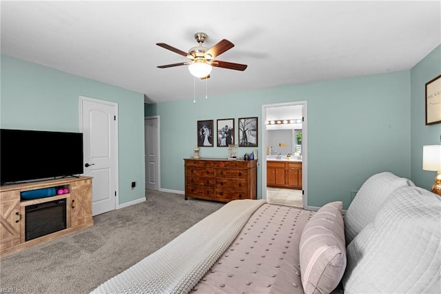 bedroom featuring carpet, baseboards, ensuite bathroom, and ceiling fan