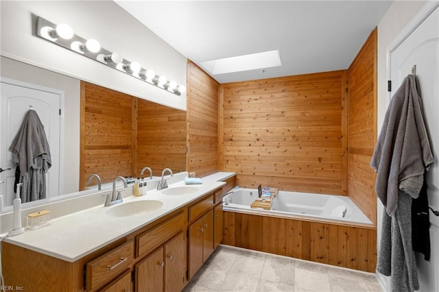 full bath with a skylight, wooden walls, a garden tub, and double vanity