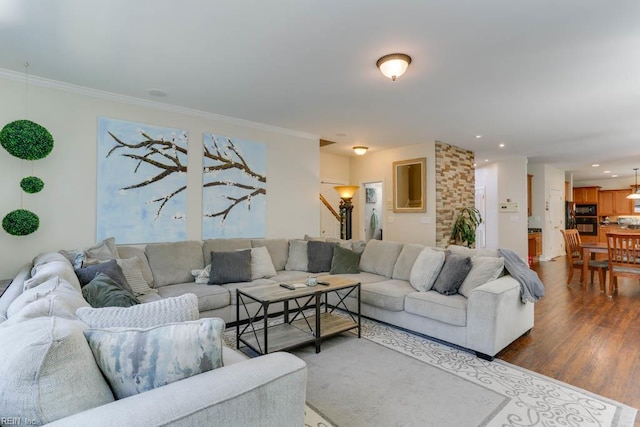 living area featuring stairs, dark wood-type flooring, ornamental molding, and recessed lighting
