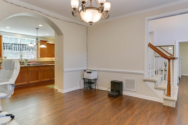 office space featuring wood finished floors, arched walkways, a chandelier, baseboards, and ornamental molding