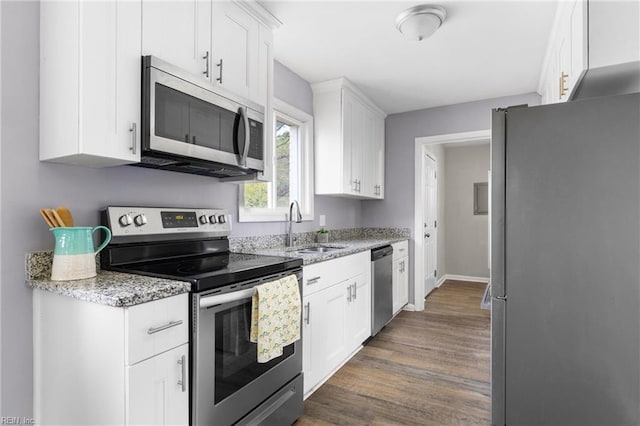 910 Truman Rd, Suffolk, VA 23434 - kitchen with stainless steel appliances, a sink, dark wood-style flooring, white cabinetry, and light stone countertops
