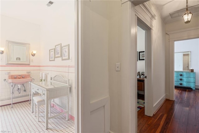 7320 Shirland Ave, Norfolk, VA 23505 - corridor featuring wood finished floors, wainscoting, tile walls, and a sink