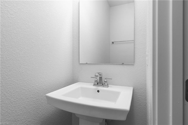 bathroom with a textured wall and a sink