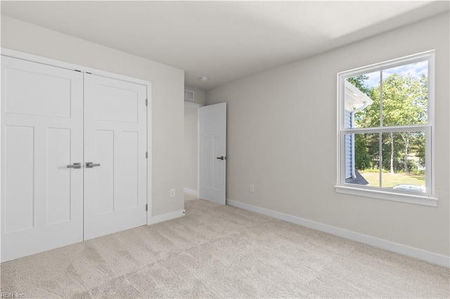unfurnished bedroom featuring carpet flooring, baseboards, and a closet