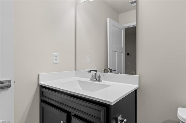 half bath featuring vanity and toilet