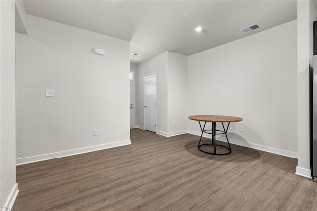 empty room with wood finished floors, baseboards, and recessed lighting