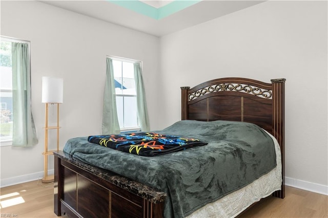 bedroom featuring light wood-style floors and baseboards