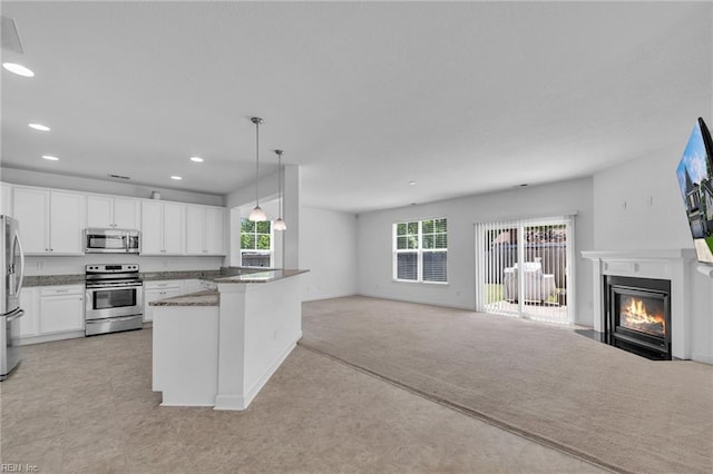 208 Mayberry Ct, Newport News, VA 23601 - kitchen featuring stainless steel appliances, open floor plan, a fireplace with flush hearth, white cabinets, and recessed lighting