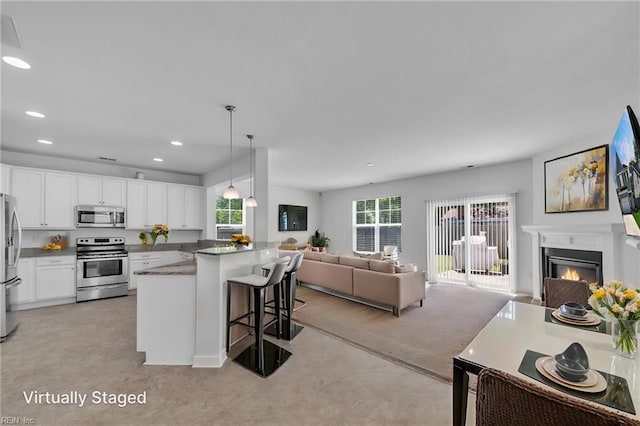 208 Mayberry Ct, Newport News, VA 23601 - kitchen with stainless steel appliances, open floor plan, a kitchen breakfast bar, white cabinetry, and pendant lighting