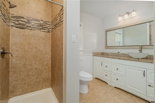 708 Harway Ave, Chesapeake, VA 23325 - bathroom with toilet, tiled shower, vanity, tile patterned floors, and a wainscoted wall