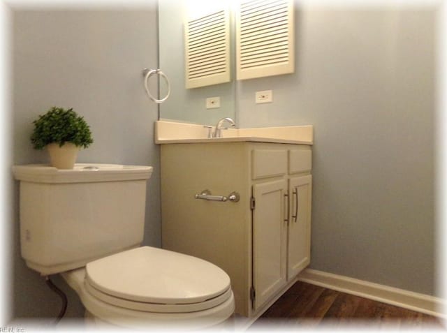 1563 N King St Unit 110, Hampton, VA 23669 - half bathroom featuring baseboards, wood finished floors, vanity, and toilet