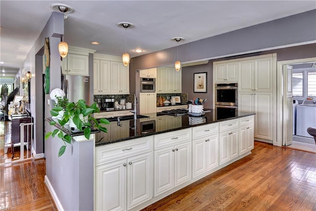 103 Acacia Ct, Williamsburg, VA 23185 - kitchen featuring washer / clothes dryer, light wood-style floors, a sink, white cabinets, and decorative backsplash