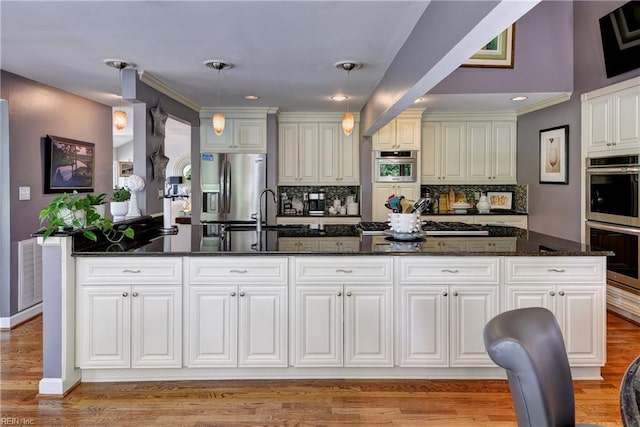 103 Acacia Ct, Williamsburg, VA 23185 - kitchen featuring appliances with stainless steel finishes, backsplash, a sink, dark stone counters, and crown molding