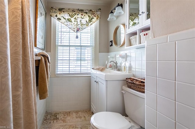 200 Ferguson Ave, Newport News, VA 23601 - bathroom with tile walls, toilet, healthy amount of natural light, vanity, and a wainscoted wall