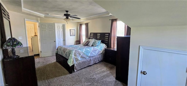 carpeted bedroom featuring a raised ceiling and ceiling fan