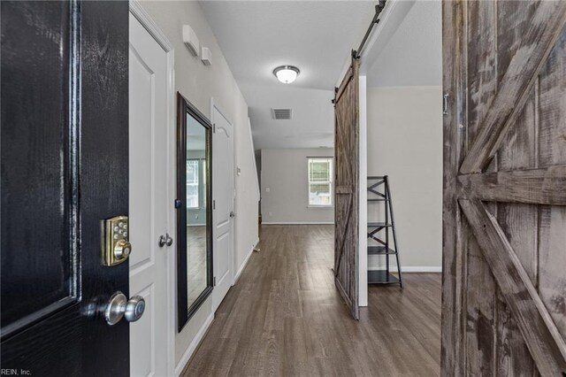 3001 Ravine Gap Dr, Suffolk, VA 23434 - hallway featuring a barn door, wood finished floors, and baseboards