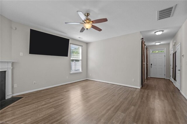 3001 Ravine Gap Dr, Suffolk, VA 23434 - unfurnished living room featuring wood finished floors, a ceiling fan, baseboards, and a fireplace