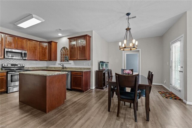 3001 Ravine Gap Dr, Suffolk, VA 23434 - kitchen with appliances with stainless steel finishes, dark wood-style flooring, a chandelier, and backsplash