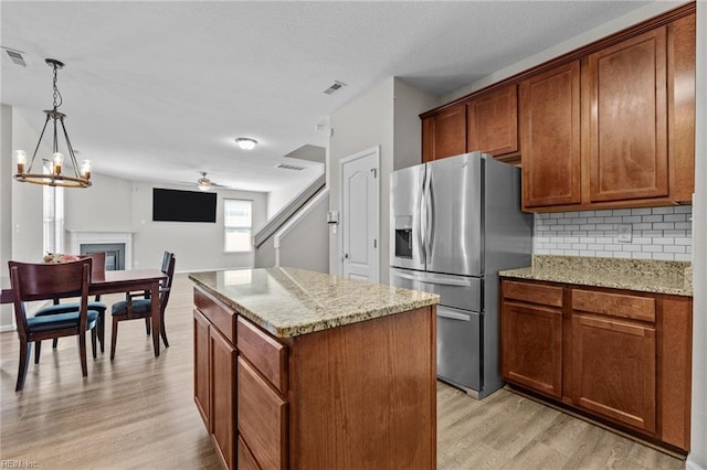 3001 Ravine Gap Dr, Suffolk, VA 23434 - kitchen featuring stainless steel fridge with ice dispenser, light wood-type flooring, decorative backsplash, a center island, and a ceiling fan
