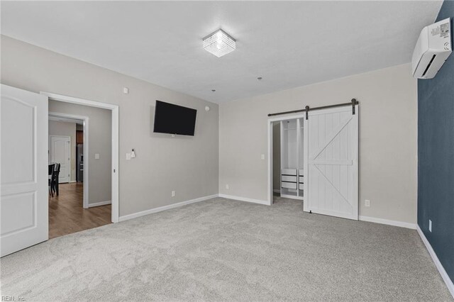 3001 Ravine Gap Dr, Suffolk, VA 23434 - unfurnished bedroom featuring carpet floors, baseboards, an AC wall unit, and a barn door