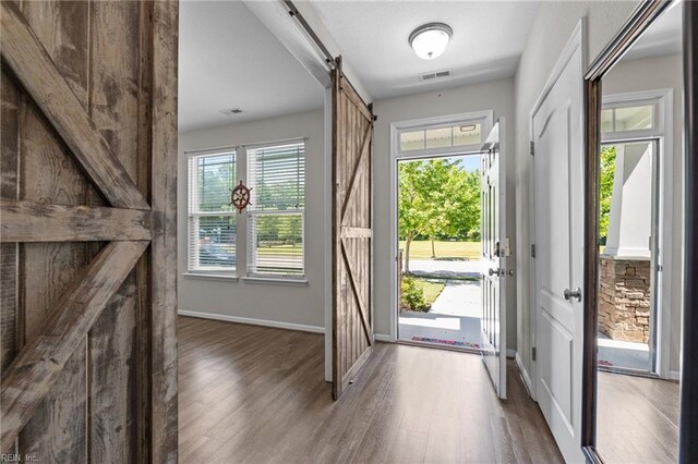 3001 Ravine Gap Dr, Suffolk, VA 23434 - entryway featuring a barn door, wood finished floors, and baseboards