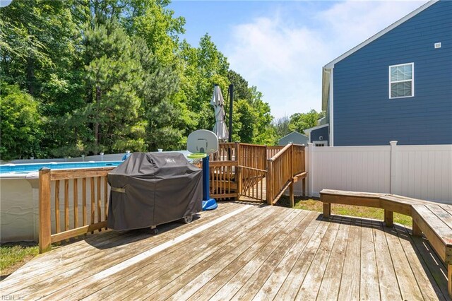 3001 Ravine Gap Dr, Suffolk, VA 23434 - wooden terrace featuring an outdoor pool, a fenced backyard, a grill, and view of wooded area