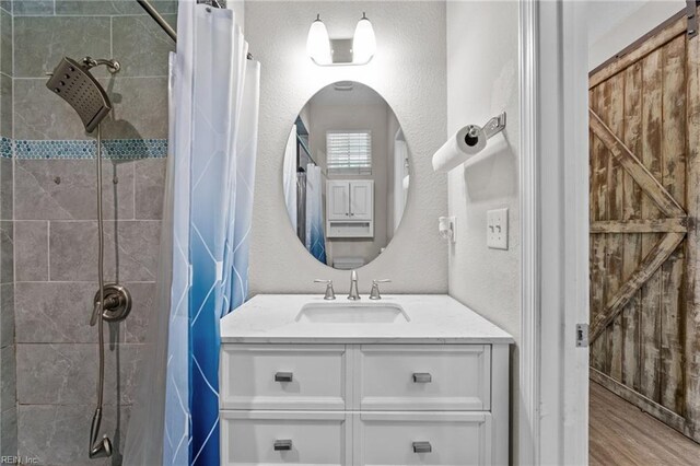3001 Ravine Gap Dr, Suffolk, VA 23434 - bathroom featuring a tile shower, vanity, and wood finished floors
