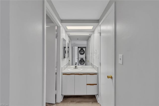 3556 Shore Dr Unit 704, Virginia Beach, VA 23455 - bathroom with stacked washer / dryer, vanity, and wood finished floors